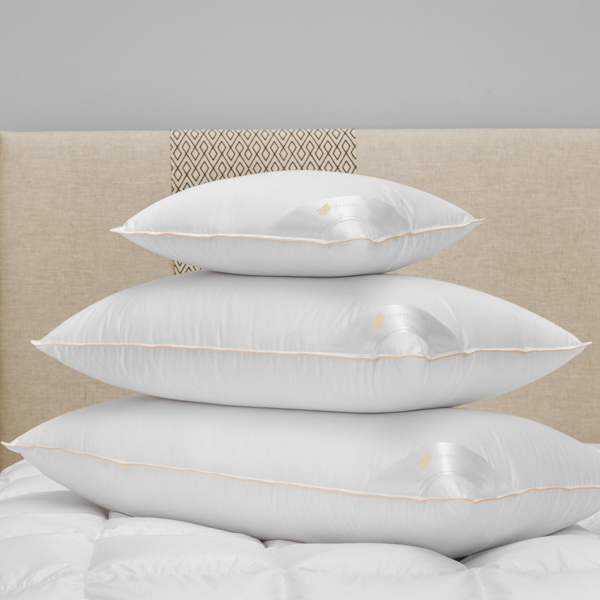 stack of 3 Hungarian goose down pillows on bed, various sizes, white